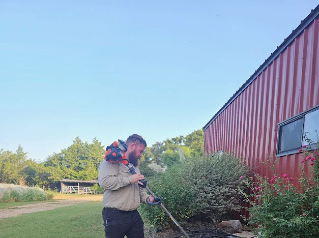 Good Sons Outdoor Services crew member maintaining landscaping in Brenham, Texas