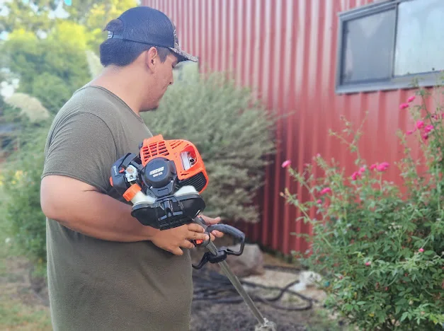 Good Sons Outdoor Services crew member trimming landscaping in Brenham, Texas